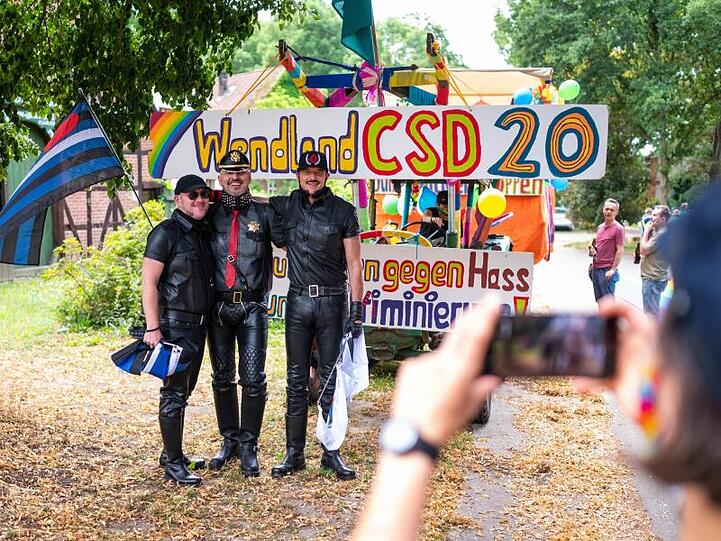 Teilnehmer der Parade Christopher Street Day (CSD) vor einem Trecker im Wendland.