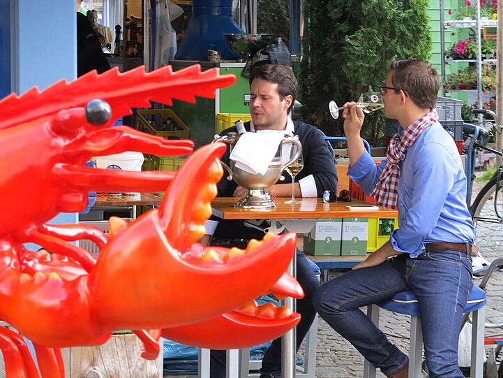 Buntes Treiben mit Weisswein trinken am Viktualienmarkt.