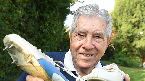 Heinz Fütterer posiert mit alten Laufschuhen aus dem Jahr 1957. Foto (2016): Uli Deck