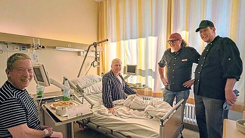 Stefan Marquard (2. von rechts) und Küchenchef Carsten Fleuren (r.) bei zwei Patienten, die gerade ihr Mittagessen bekommen haben.