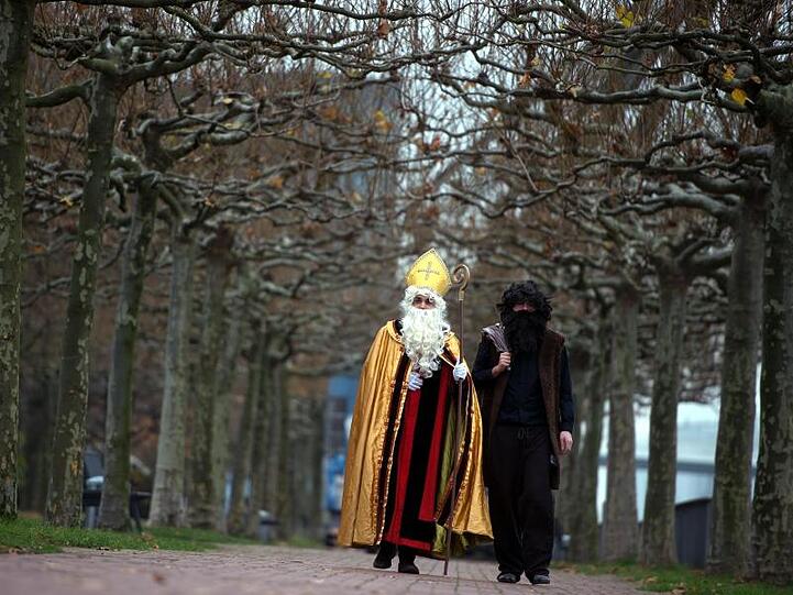 Nikolaus (l) und Knecht Ruprecht am Rheinufer in Düsseldorf.