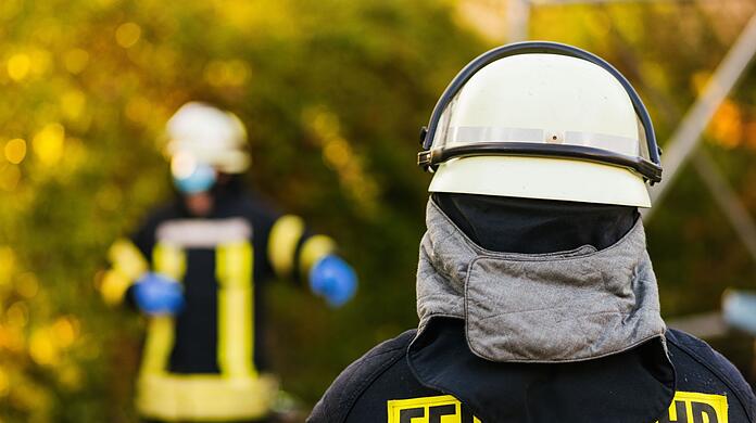 Einsatzkräfte der Feuerwehr in Schutzkleidung.