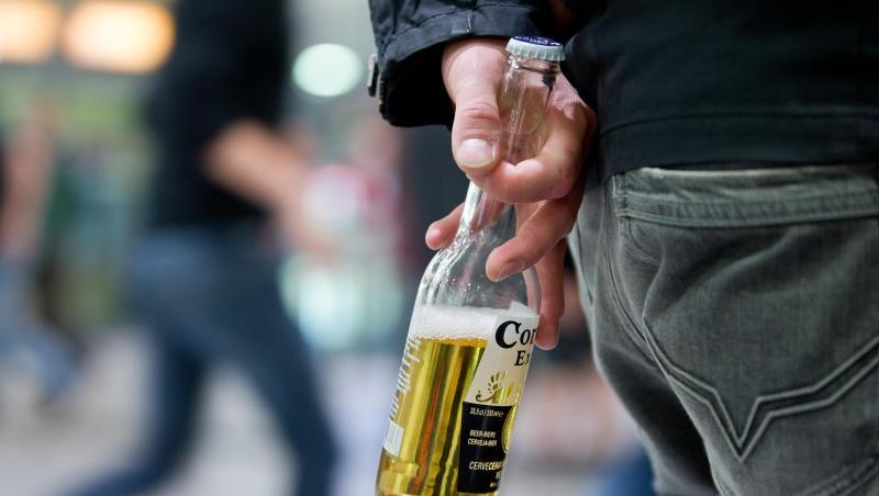 Ein Mann mit einer Flasche Bier in der Hand.