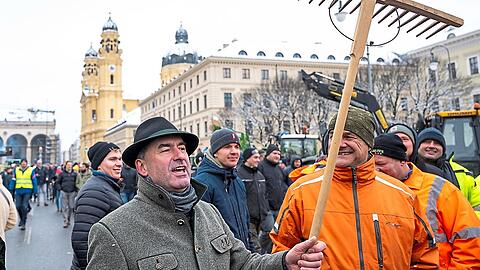 Hubert Aiwanger lässt sich von seinen Anhängern mit Harke in der Hand feiern.