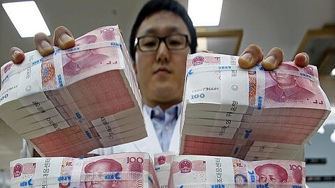 Ein Bankangestellter in Seoul stapelt Yuan-Bündel. Die Abwertung durch die chinesische Zentralbank hat auch zum Wertverlust anderer Währungen geführt, etwa des südkoreanischen Won.
