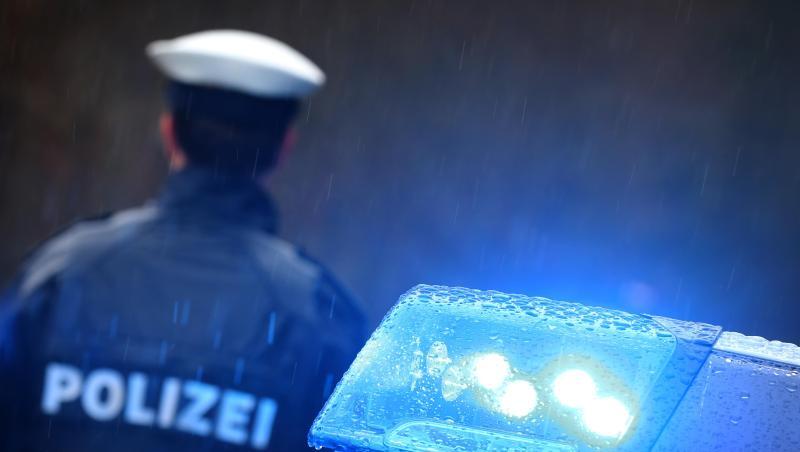 Ein Polizist steht im Regen vor einem Streifenwagen dessen Blaulicht aktiviert ist. Foto: Karl-Josef Hildenbrand/dpa Ein Polizist steht im Regen vor einem Streifenwagen dessen Blaulicht aktiviert ist. Foto: Karl-Josef Hildenbrand/dpa