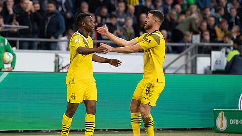 Dortmunds Youssoufa Moukoko (l) jubelt mit Dortmunds Mahmoud Dahoud nach seinem Tor zur Führung.