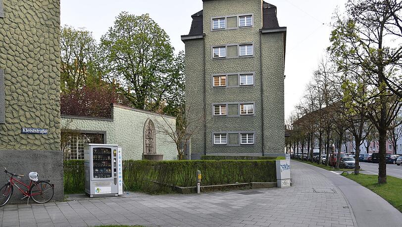 Entree der Siedlung in Untergiesing zur Stadt hin. An der Stelle stand zur Bauzeit ein großer Baum, um den herumgeplant wurde. Dort erinnert in der Brunnenwand auch eine Bautafel an die Erbauer.