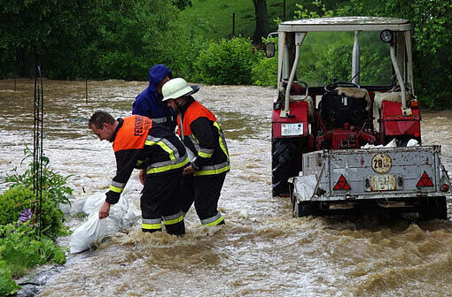 Feuerwehrleute arbeiten im Hochwasser in Kumbach im Landkreis Günzburg (Bayern). Heftige Regenfälle haben die Wasserstände an den Donauzuflüssen in Schwaben rasant ansteigen lassen. In Günzburg wurde Katastrophenalarm ausgerufen.