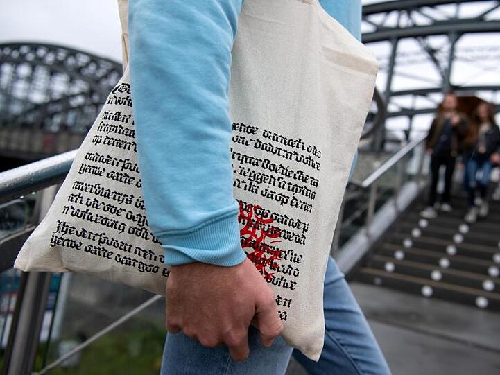 Ein Mann läuft mit einer Einkaufstüte des Münchner Buchhändlers Hugendubel eine Treppe rauf. Foto: Sven Hoppe/dpa/Archivbild