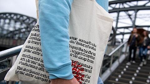 Ein Mann läuft mit einer Einkaufstüte des Münchner Buchhändlers Hugendubel eine Treppe rauf. Foto: Sven Hoppe/dpa/Archivbild