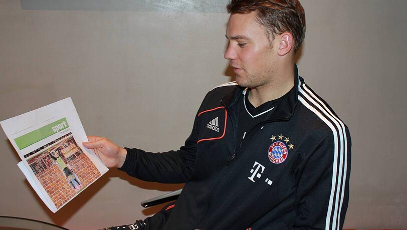 Manuel Neuer blickt auf eine Fotomontage der Abendzeitung, die ihn im Tor des FC Bayern vor einer Mauer zeigt. Manuel Neuer blickt auf eine Fotomontage der Abendzeitung, die ihn im Tor des FC Bayern vor einer Mauer zeigt.