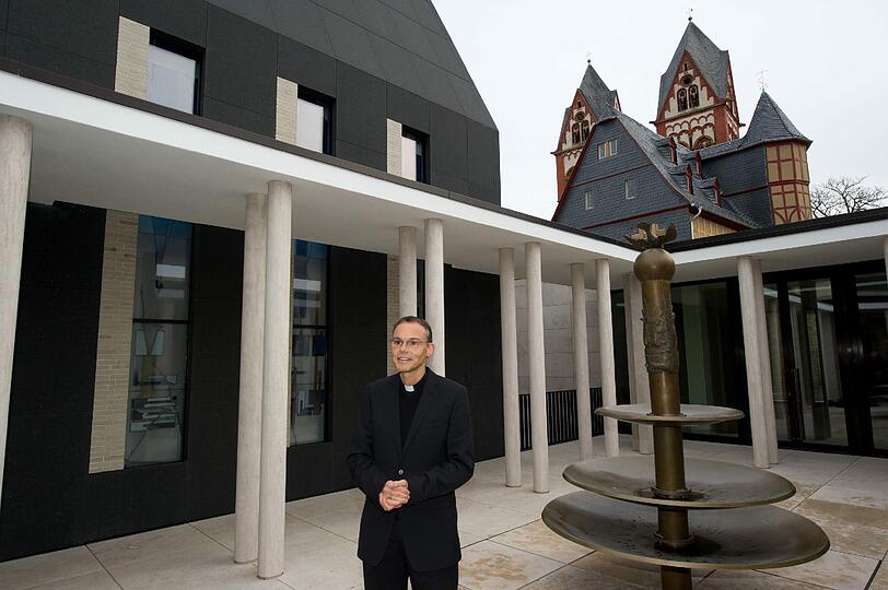 Auf diesem Foto ahnt Tebartz-van Elst noch nicht, dass er nie in seinen Prunkpalast einziehen wird. Stolz zeigt er den offenen Innenhof der bischöflichen Residenz vor dem Dom von Limburg.