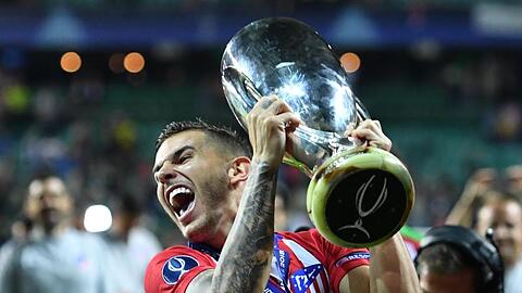 Lucas Hernandez von Atletico Madrid jubelt mit dem Pokal. Foto: Marius Becker/Archiv