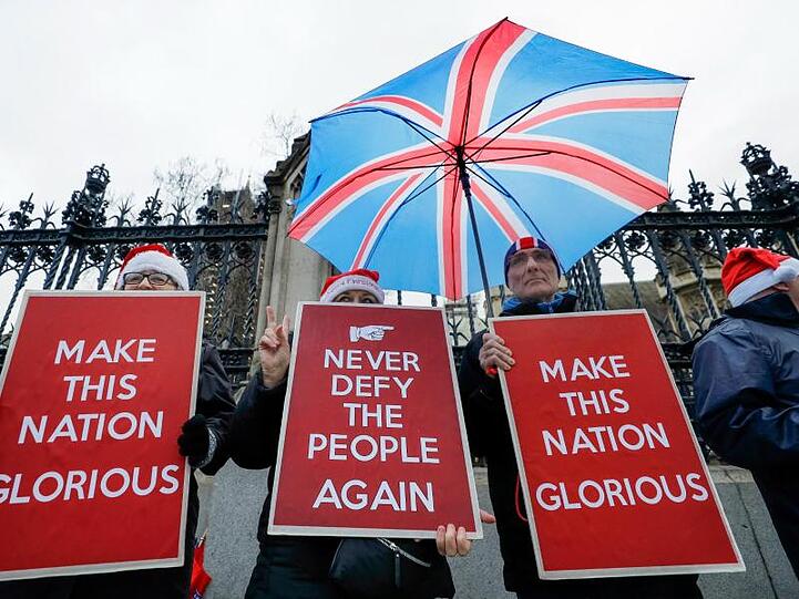 Befürworter des Brexit halten Plakate mit den Aufschriften "Never defy the people again" (Bietet den Bürgern nie wieder die Stirn) und "Make this nation glorious" (Macht diese Nation prächtig) vor dem britischen Parlament.