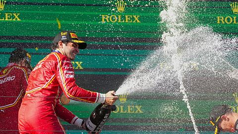 Ferrari-Pilot Carlos Sainz feiert mit Champagner seinen Sieg.