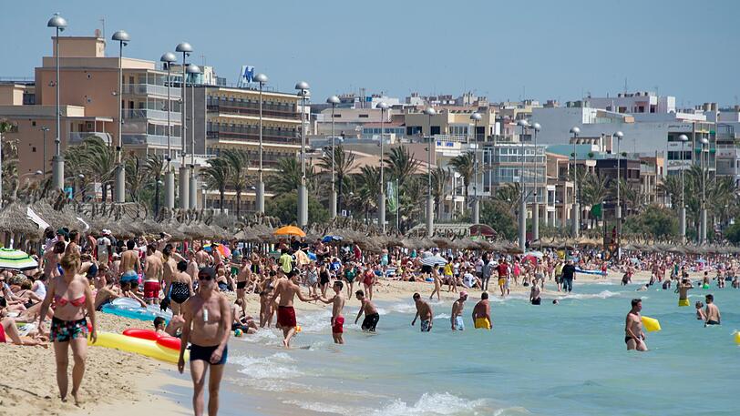 Urlauber tummeln sich auf der Mittelmeerinsel Mallorca am Strand von Arenal.