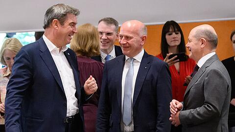 Markus Söder (l-r, CSU), Ministerpräsident von Bayern, Kai Wegner (CDU), Regierender Bürgermeister von Berlin, und Bundeskanzler Olaf Scholz (SPD) unterhalten sich zu Beginn des Bund-Länder-Gipfels.