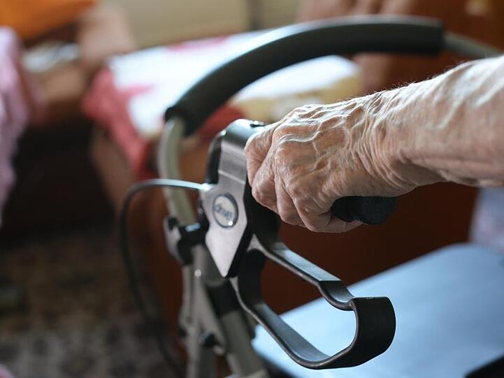 Eine Seniorin bewegt sich mit einem Rollator durch ihr Zimmer. Foto: Jens Kalaene/dpa-Zentralbild/dpa/Symbolbild