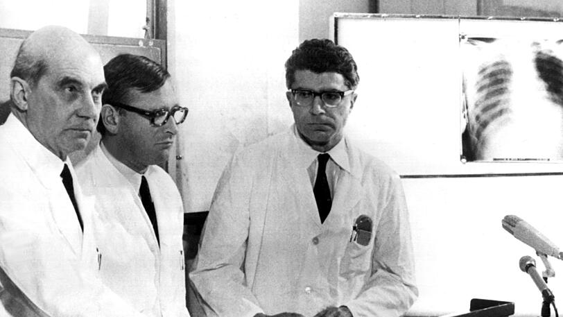 Die Münchner Chirurgen Professor Dr. Rudolf Zenker (l.), Werner Rudolph (m.) und Werner Klinner (r.) bestätigen am 14. Februar 1969 vor Journalisten, dass am Vortag die erste Herztransplantation in der Bundesrepublik durchgeführt wurde.