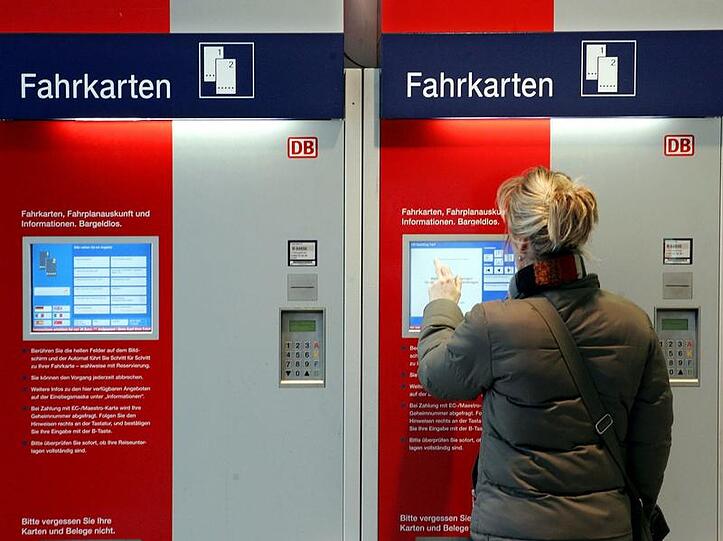 Eine Frau an einem Fahrkartenautomaten der Deutschen Bahn.