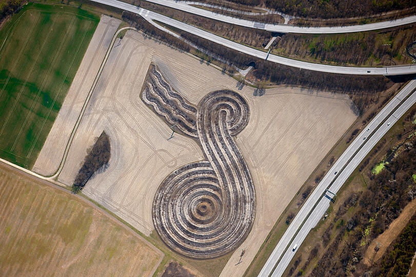 Wilhelm Holderied und des Bildhauers Karl Schlamminger haben dieses Erdzeichen am Flughafen angelegt. Die Furchen sind 3,40 Meter tief.