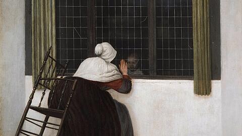 Typisch für Jacobus Vrel ist ein Innenraum mit einer einzigen Person – gerne in Rückenansicht. Oft sind es Frauen, die ganz in ihre Arbeit vertieft sind, das kennt man auch von Johannes Vermeer. In diesem nach 1656 entstandenen Gemälde winkt vielleicht eine Großmutter einem Kind durchs Fenster zu. Dabei kommt ihr Stuhl fast zum Kippen. Auch der Papierfetzen am Boden deutet auf Vrel.