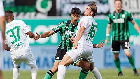 Der Fürther Lukas Petkov (r) kämpft mit Muhammed Mehmet Damar (M) von Hannover 96 um den Ball.