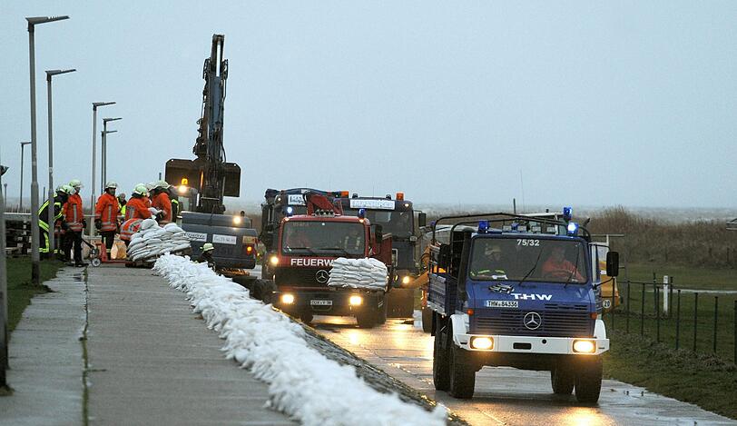 Die Feuerwehr und das THW rückt an, um den Deich in Cuxhaven mit Sandsäcken zu sichern