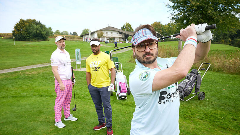 Golffieber in Niederkaltenkirchen: Simmerl (Stephan Zinner, l.) und Flötzinger (Daniel Christensen, r.) versuchen sich unter Aufsicht von Golflehrer Buengo (Castro Dokyi Affum, m.) auf dem Grün. Golffieber in Niederkaltenkirchen: Simmerl (Stephan Zinner, l.) und Flötzinger (Daniel Christensen, r.) versuchen sich unter Aufsicht von Golflehrer Buengo (Castro Dokyi Affum, m.) auf dem Grün.