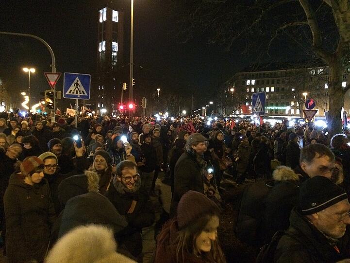 Die Gegendemonstranten machen ihre Handy-Lichter an.