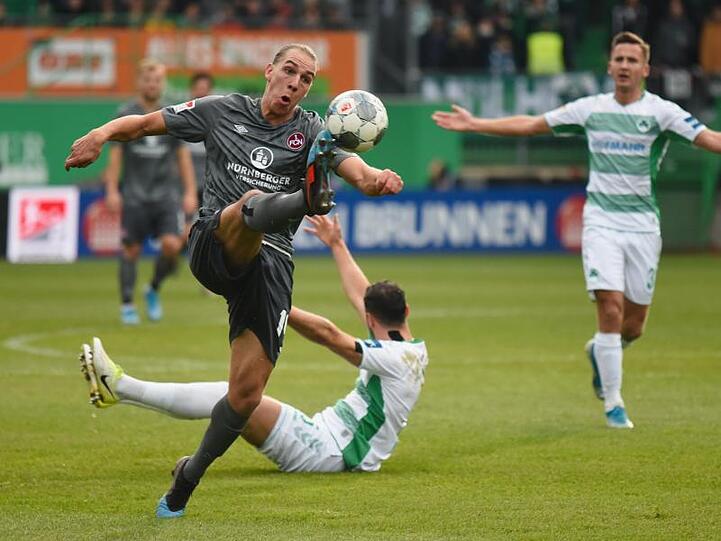 Nürnbergs Michael Frey (l) kämpft um den Ball, im Hintergrund sind Fürths Mergim Mavraj (M) und Paul Seguin (r)zu sehen. Foto: Nicolas Armer/dpa/Archivbild