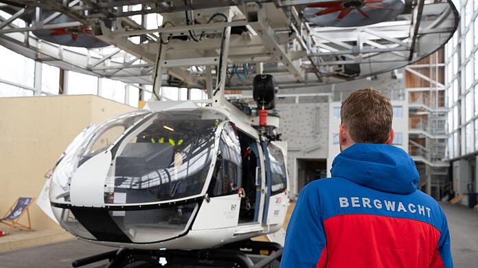 Im Bergwacht-Zentrum für Sicherheit und Ausbildung steht ein Mitglied der Bergwacht Bayern vor einem Hubschrauber-Modell. (Archivbild)