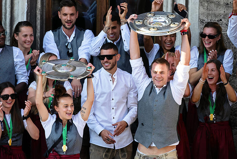 Bayerns Manuel Neuer (Mitte r) und Lina Magull (Mitte l) jubeln mit den Meisterschalen auf dem Rathaus-Balkon. Die Männer des FC Bayern München sind zum elften Mal in Serie deutscher Fußball-Meister, die Fußballerinnen des FC Bayern haben sich ihren fünften deutschen Meistertitel gesichert.
