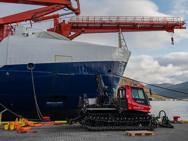 Ein Pisten-Bully vor dem Bug der der "Polarstern": Das Gerät soll dabei helfen, auf dem Eis eine Start- und Landebahn zu bauen.