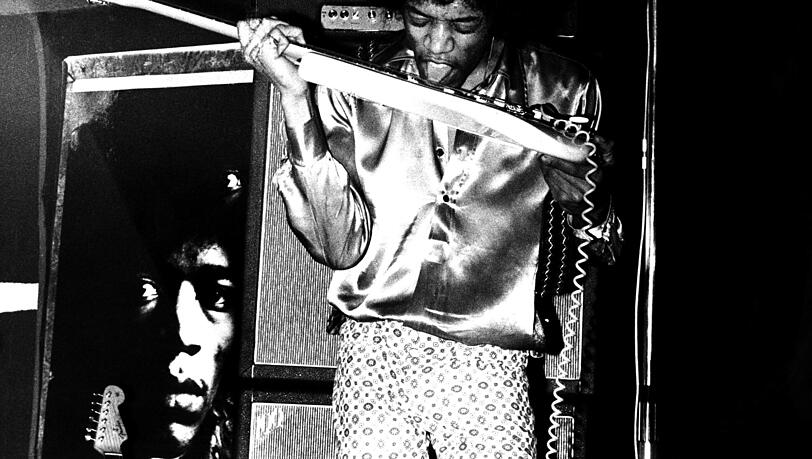 Unnachahmlich: Der US-amerikanische Rocksänger und Gitarrist Jimi Hendrix spielt seine elektrische Gitarre mit der Zunge und den Zähnen. Jimi Hendrix' Leben endete so wie viele seiner sagenhaften Konzerte: In einem Rausch. Er wurde nur 27 Jahre alt.
