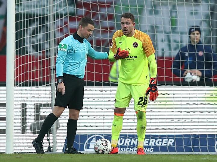 Der Nürnberger Torwart Christian Mathenia (r.) steht nach einem Zusammenstoß benommen neben Schiedsrichter Robert Kampka. Foto: Daniel Karmann