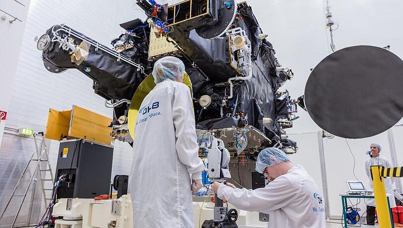 Großes Bild: Mitarbeiter des Satellitenbauers OHB, die am Produktionsstandort in Ottobrunn die Funktionsfähigkeit eines Telekommunikationssatelliten SmallGEO-Satellit H36W-1 überprüfen.