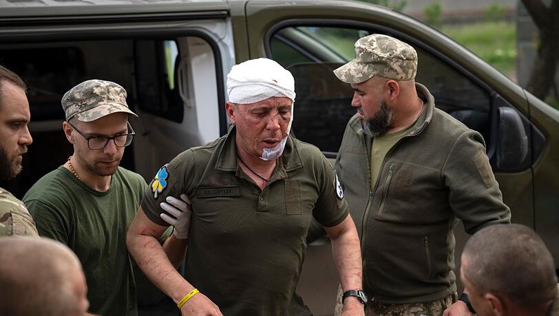 Ukrainische Soldaten helfen einem verwundeten Kameraden an einem medizinischen Stabilisierungspunkt in der Nähe von Bachmut.
