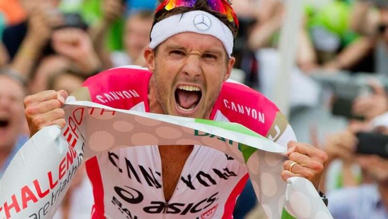 Der deutsche Triathlet Jan Frodeno überquert als Erster die Ziellinie. Foto: Daniel Karmann/dpa/Archivbild Der deutsche Triathlet Jan Frodeno überquert als Erster die Ziellinie. Foto: Daniel Karmann/dpa/Archivbild