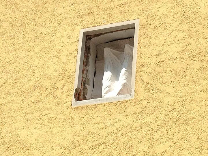 Um die Frau zu beeindrucken, macht der Mann einen Handstand am Fenster.