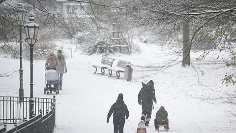 Menschen spazieren durch den verschneiten Volkspark Friedrichshain in&nbsp;Berlin.