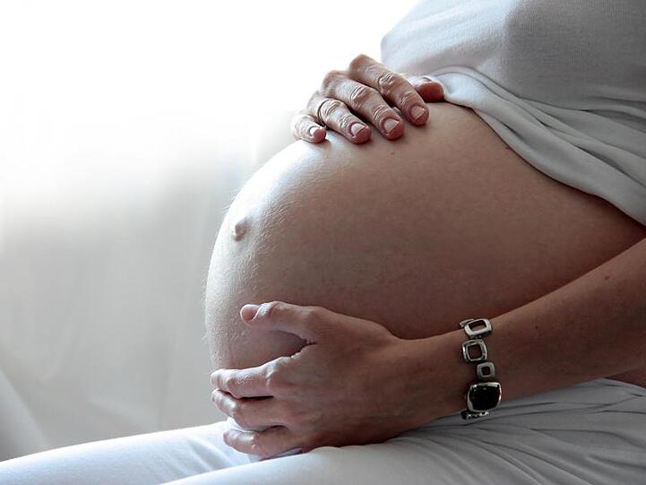 Eine Frau hält ihren schwangeren Bauch. Foto: Mascha Brichta/dpa-tmn/dpa/Archivbild