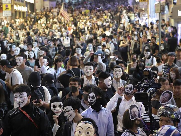 Maskierte Demonstranten versammeln sich auf einer Straße in Hongkong.
