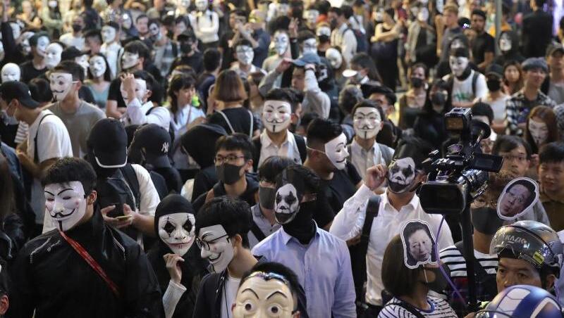 Maskierte Demonstranten versammeln sich auf einer Straße in Hongkong. Maskierte Demonstranten versammeln sich auf einer Straße in Hongkong.