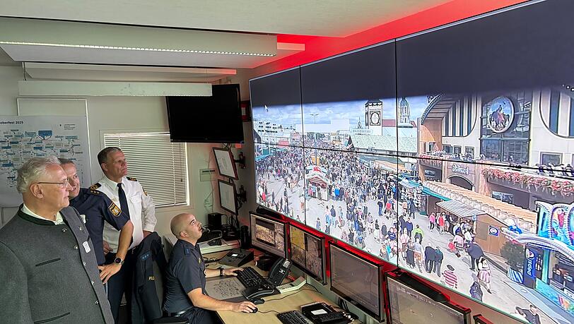 Innenminister Joachim Herrmann (li.) in der Einsatzzentrale der Wiesnwache vor der hochmodernen und nagelneuen Videowand, auf der die Beamten das Geschehen auf der Theresienwiese verfolgen können.