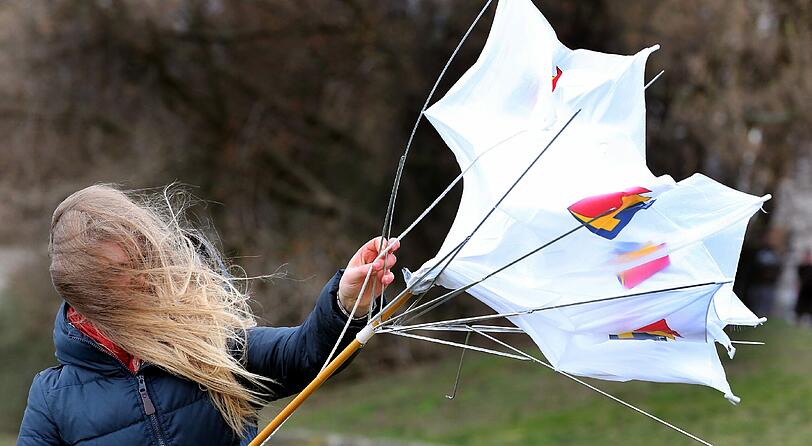 Eine junge Frau versucht am 30.03.2015 bei Sturmböen in Berlin ihren Regenschirm zu bändigen. Nach Angaben der Meteorologen wird in den kommenden Tagen weiter mit Regenschauern und heftigen Windböen, bei Temperaturen im einstelligen Bereich, zu rechnen sein.