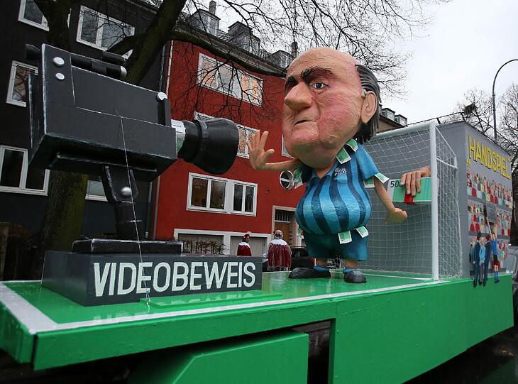 Ein Motivwagen mit dem Motto "Videobeweis" und einem Abbild von Sepp Blatter steht am Rosenmontag in Köln im Regen.