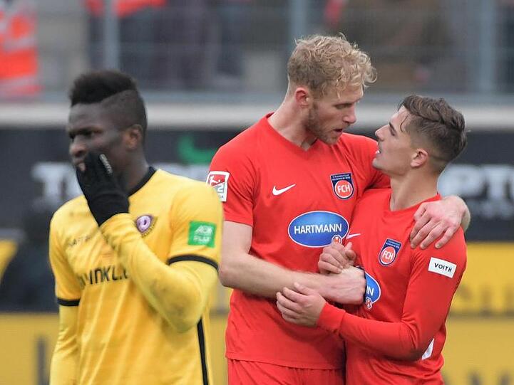 Heidenheims Nikola Dovedan (r) und Sebastian Griesbeck beglückwünschen sich neben Moussa Kone von Dynamo Dresden zum Sieg.