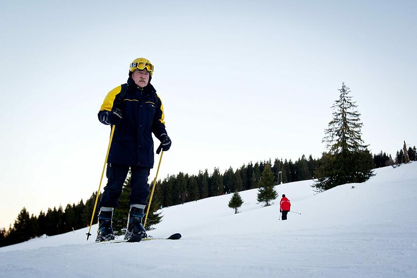 Postbote Hans Fink posiert im Skigebiet Sudelfeld bei Bayrischzell auf seinen Skiern.
